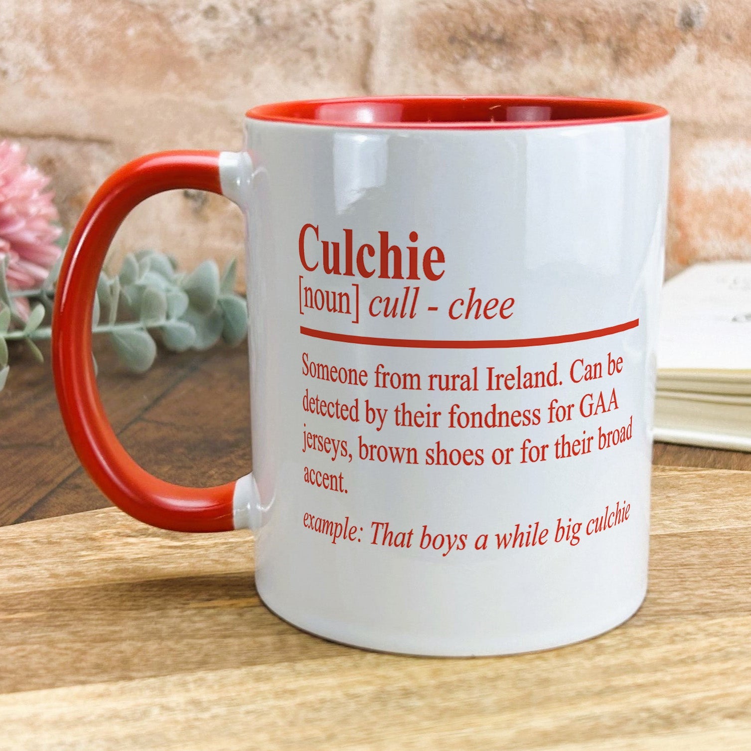 a red and white coffee mug sitting on top of a wooden table