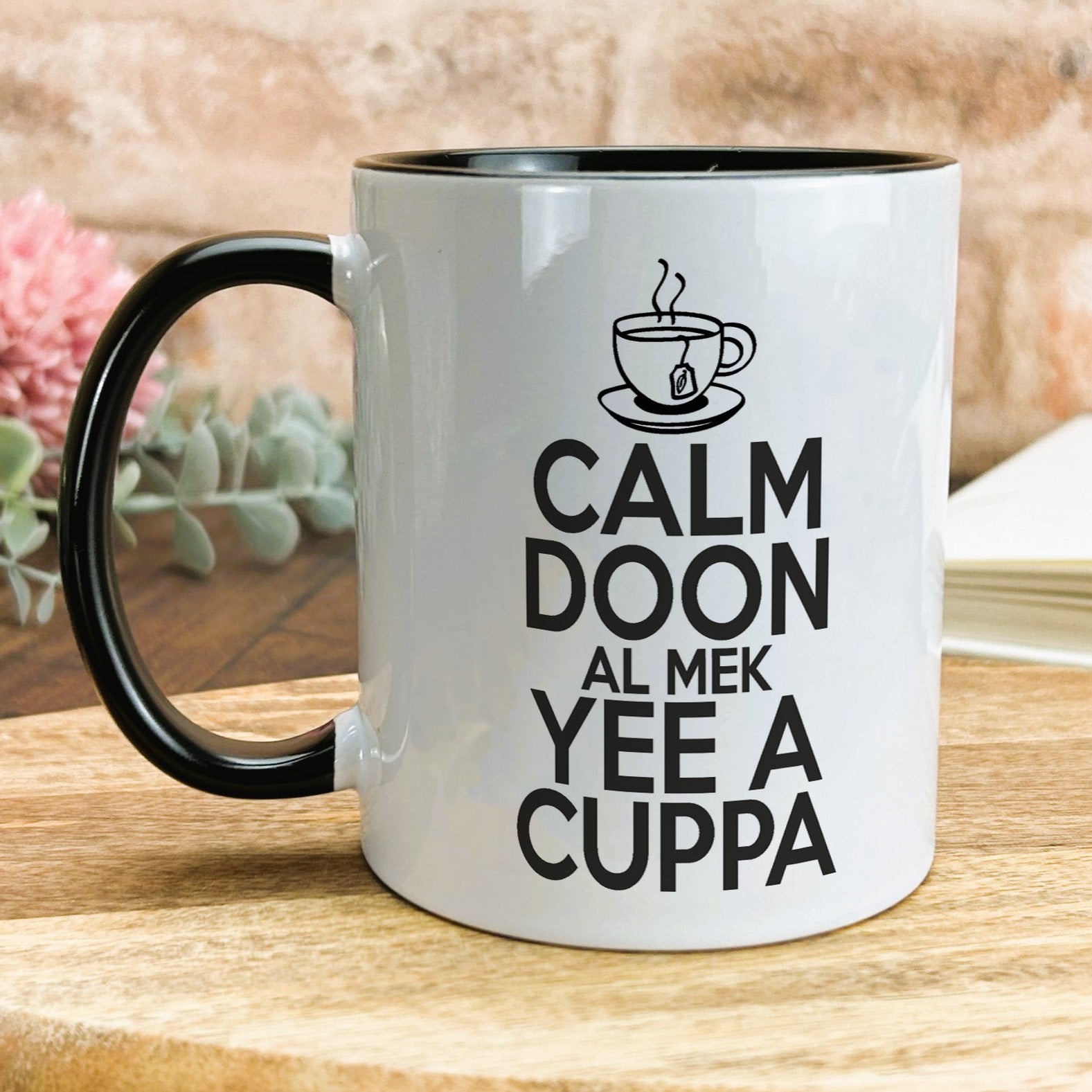 a white and black coffee mug sitting on top of a wooden table