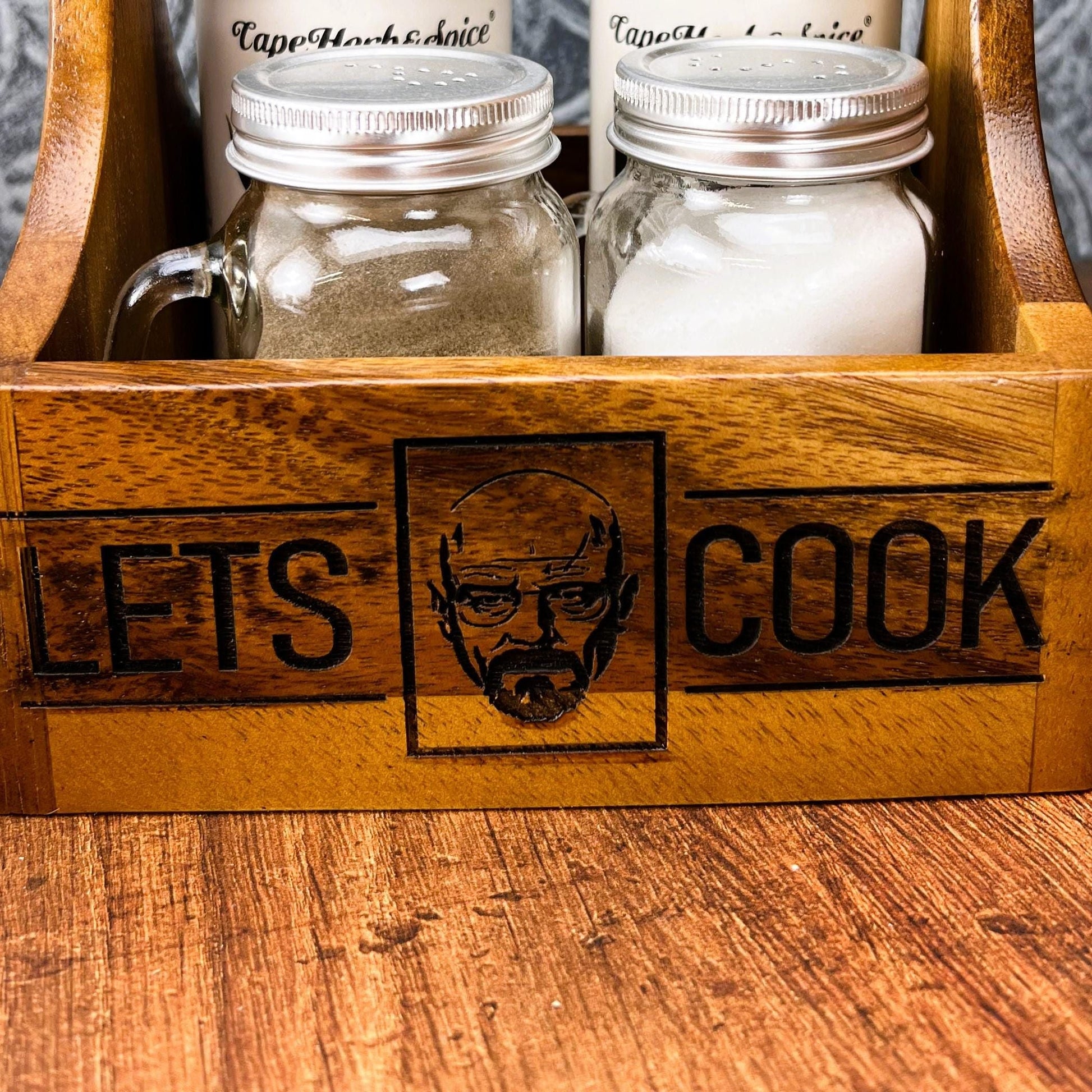 a wooden box with two jars of food inside of it
