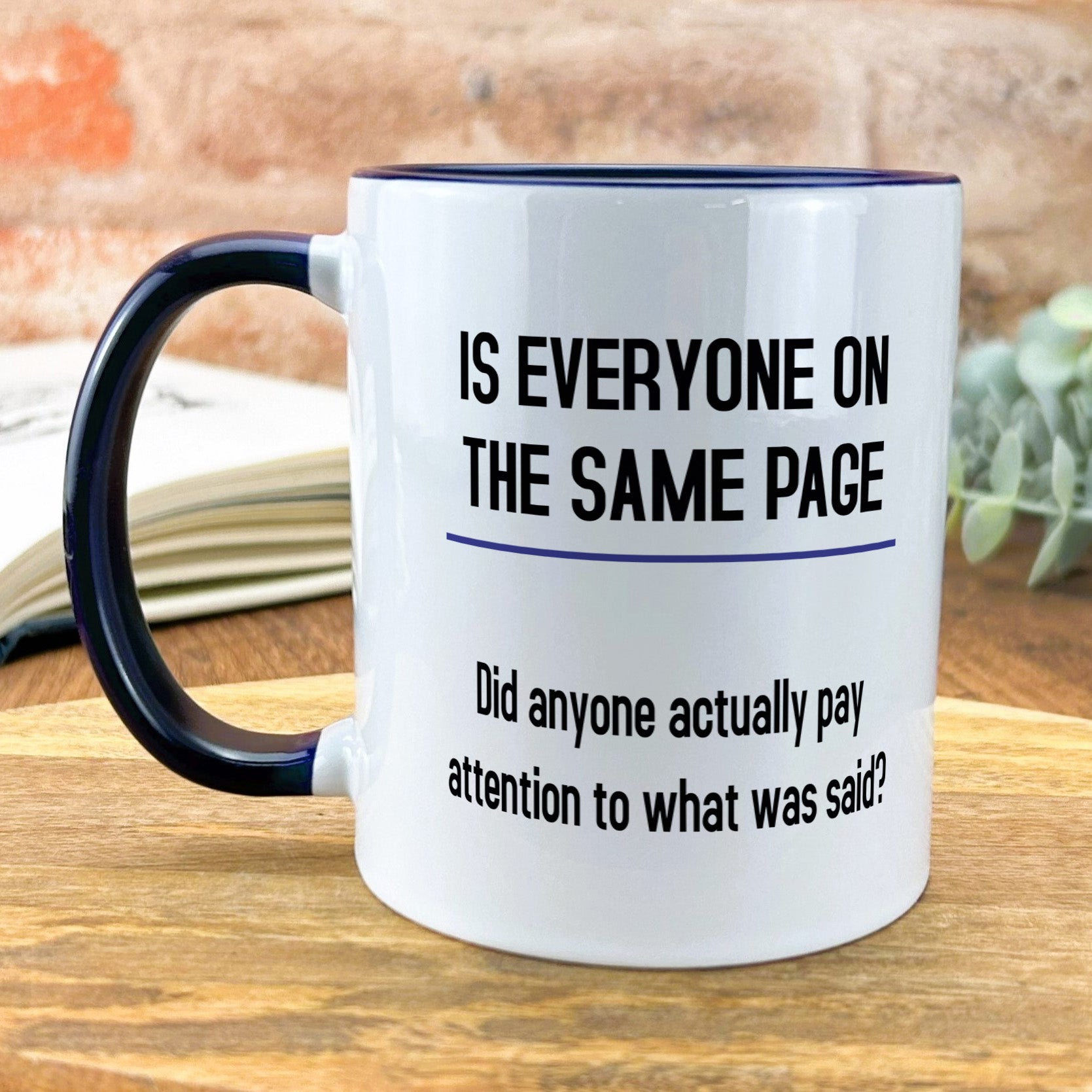 a black and white coffee mug sitting on top of a wooden table