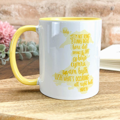 a yellow and white coffee mug sitting on top of a wooden table