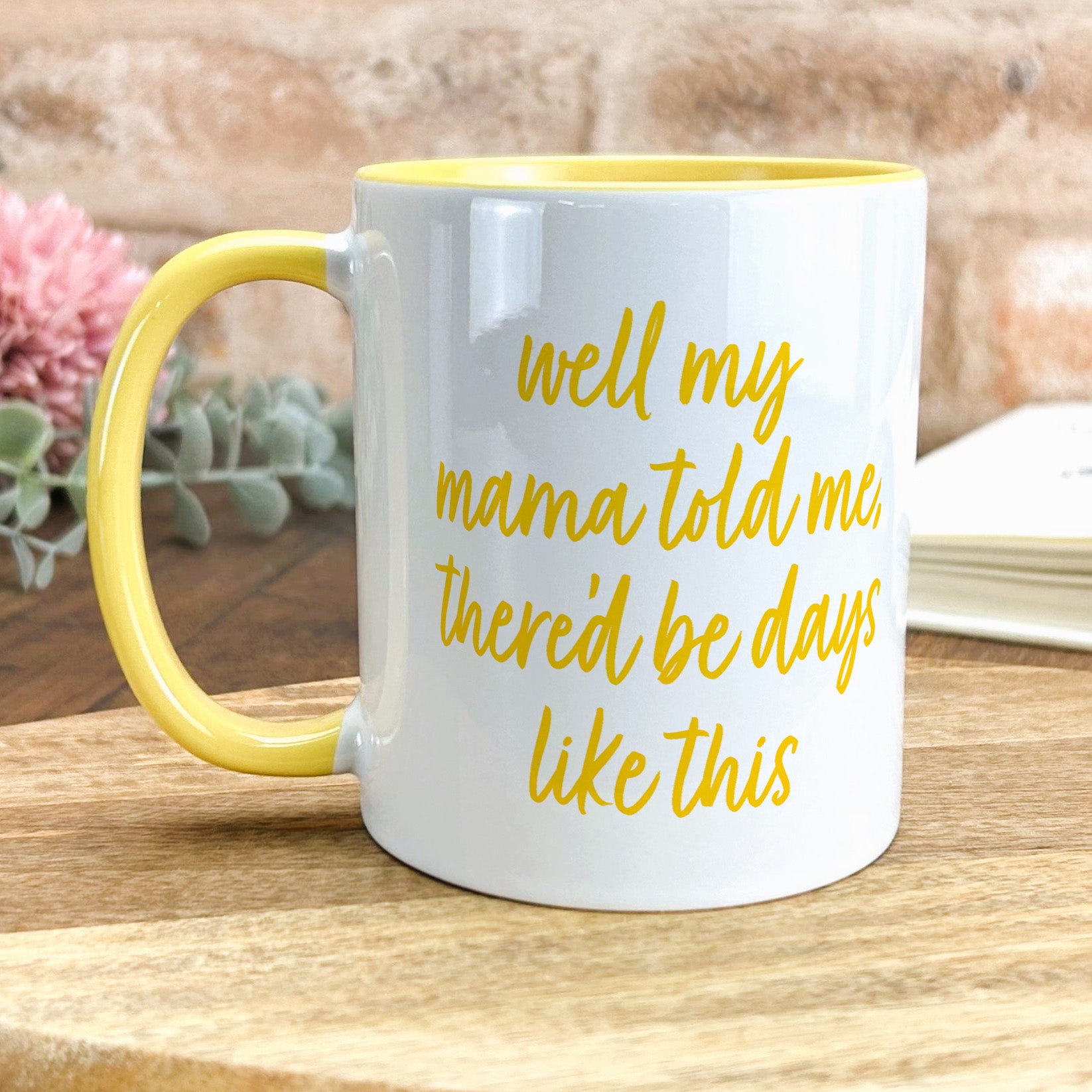 a yellow and white coffee mug sitting on top of a wooden table