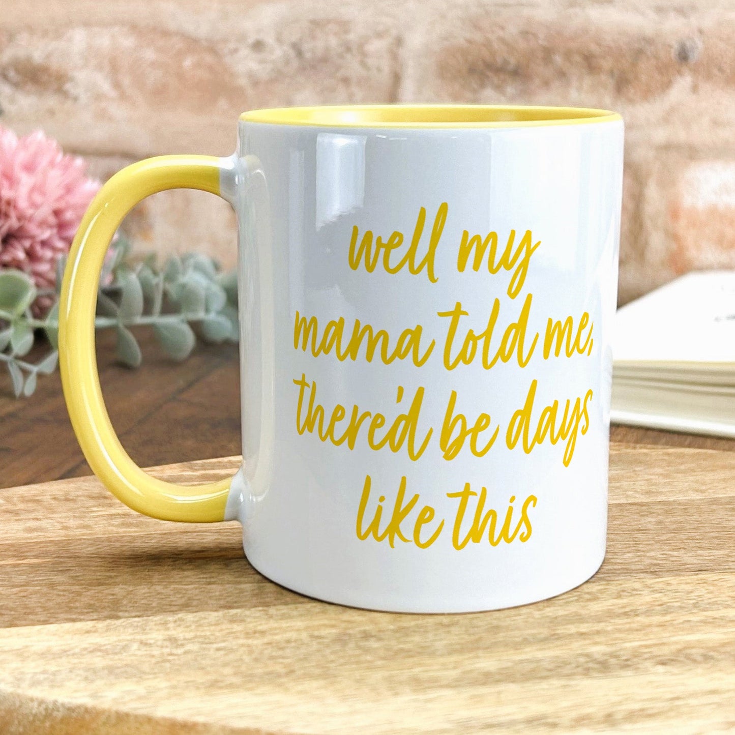 a yellow and white coffee mug sitting on top of a wooden table