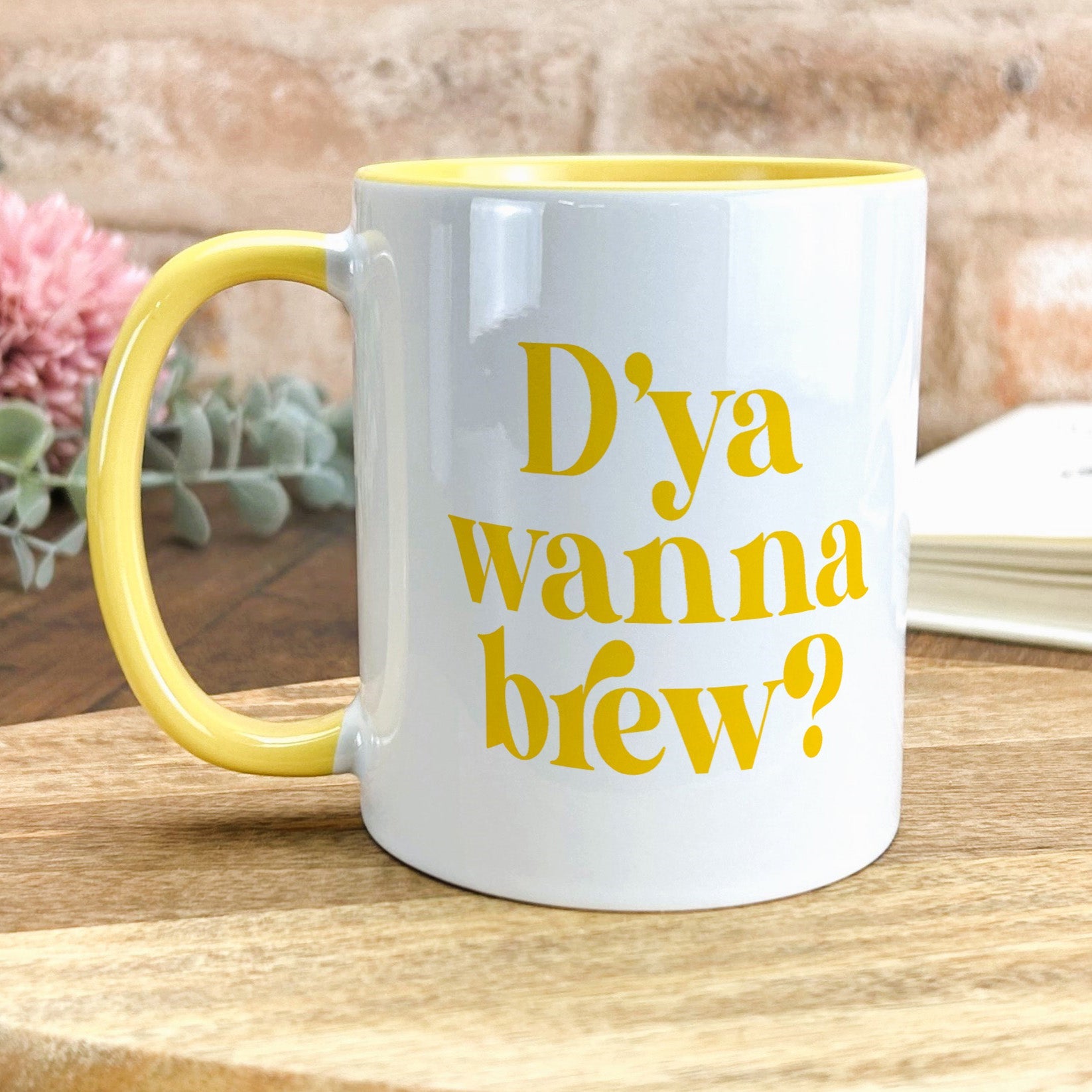 a yellow and white coffee mug sitting on top of a wooden table