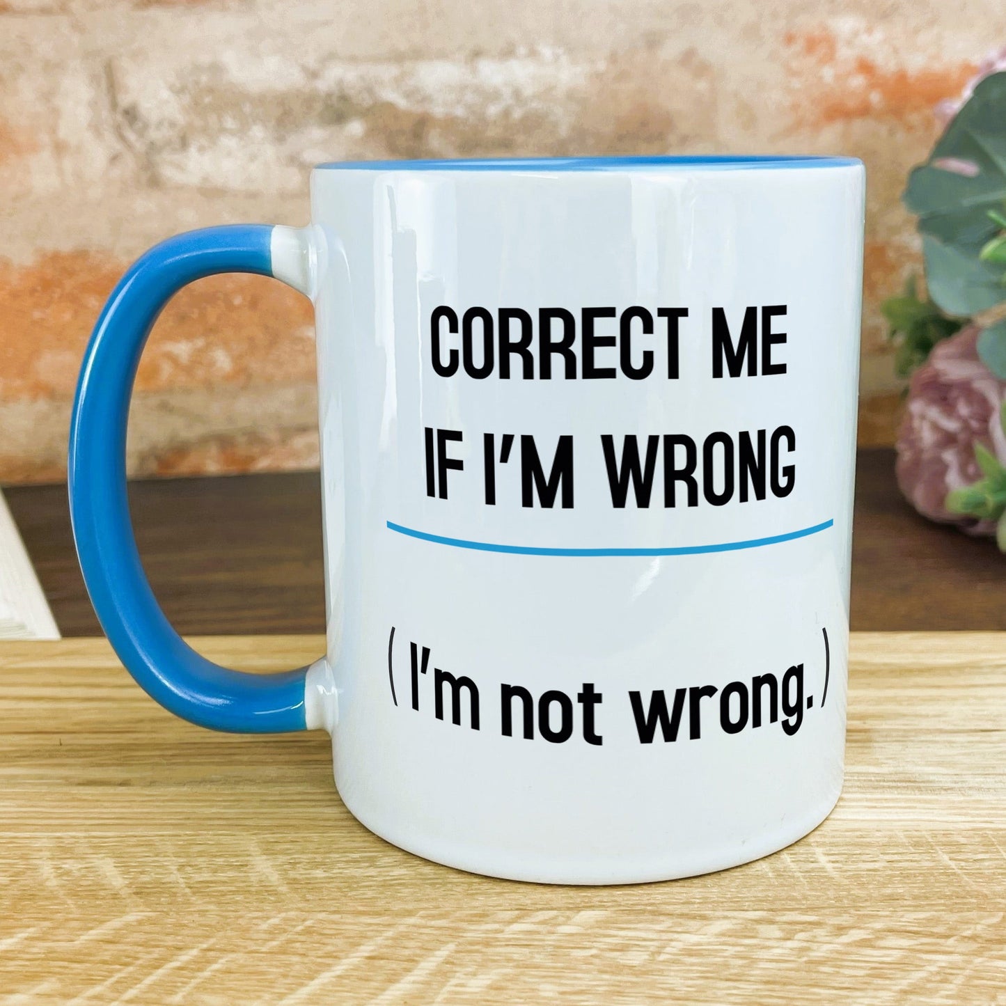 a blue and white coffee mug sitting on top of a wooden table