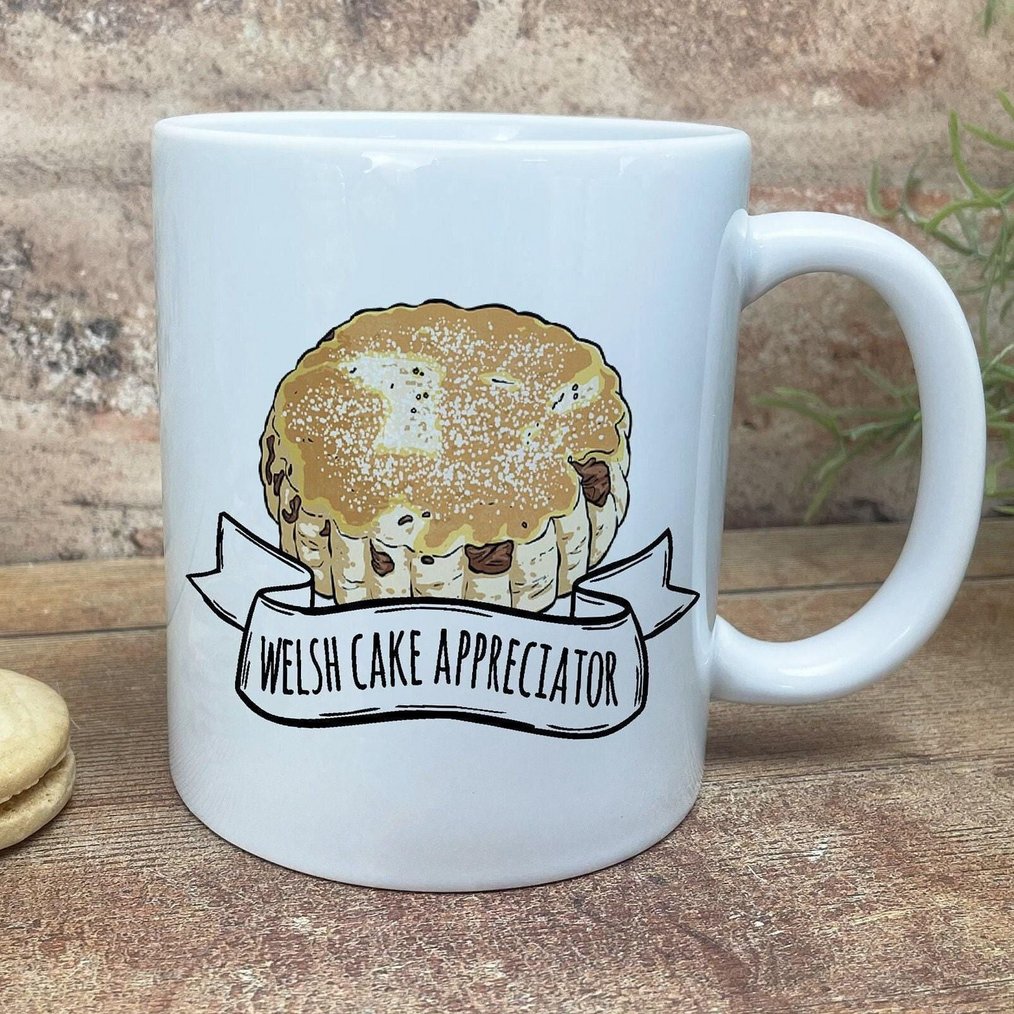A white ceramic mug with a graphic of a muffin and the text "Welsh Cake Appreciator" printed on it.