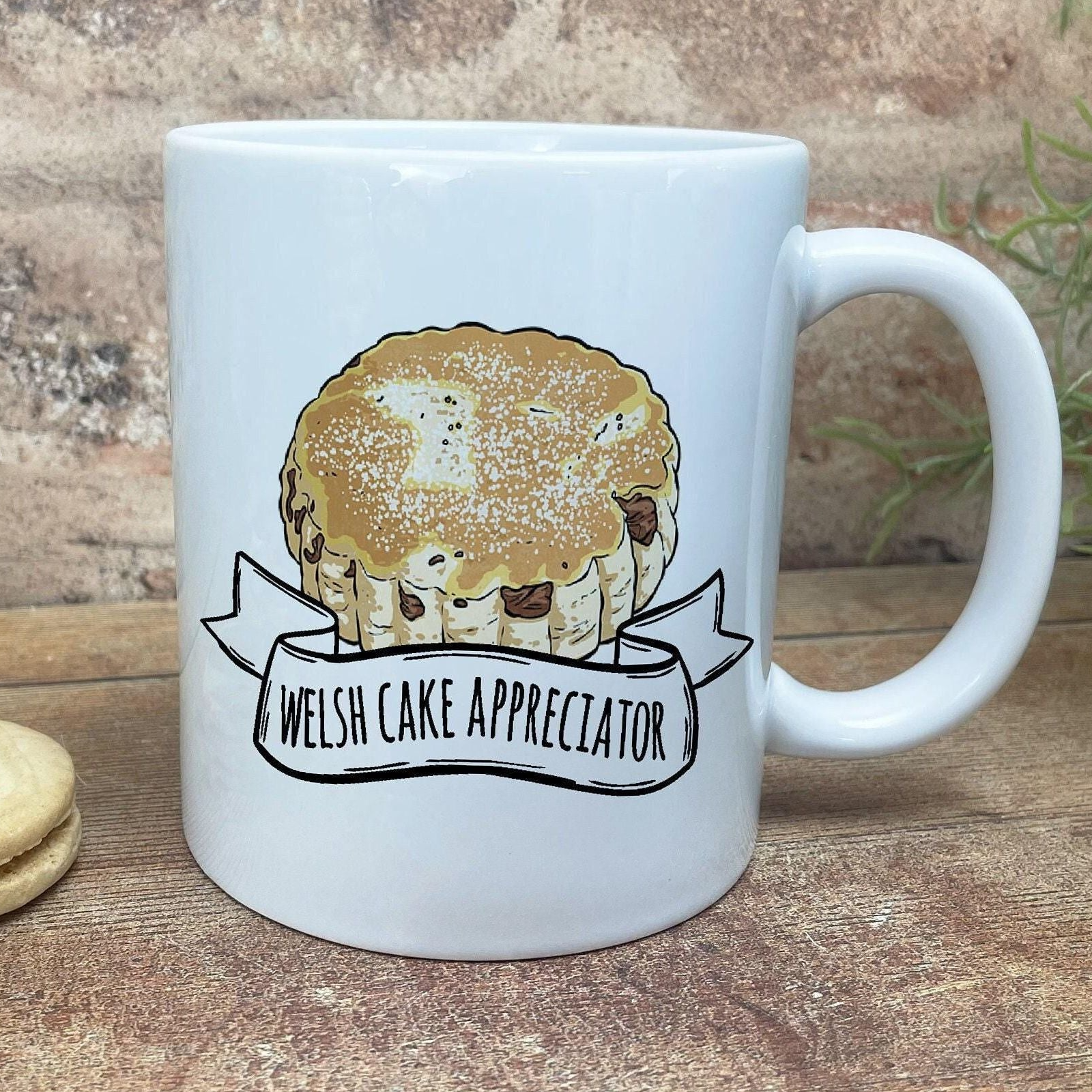 A white ceramic mug with a graphic of a muffin and the text "Welsh Cake Appreciator" printed on it.