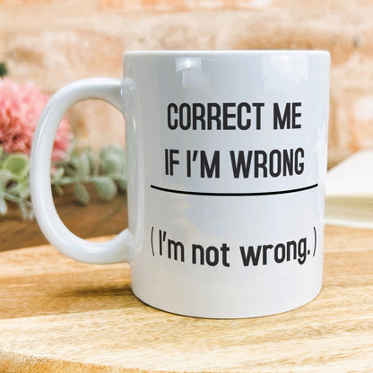 a white coffee mug sitting on top of a wooden table