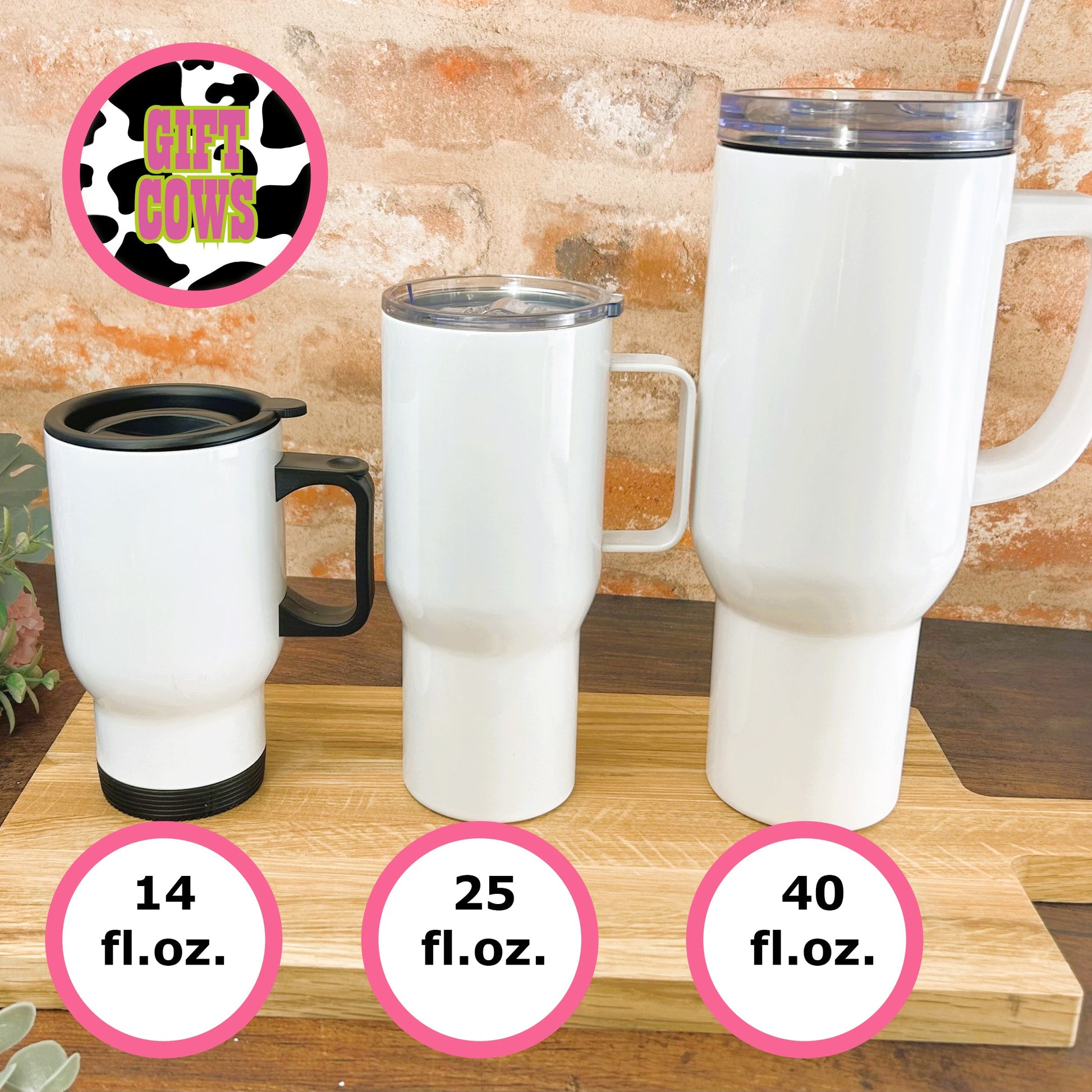 a set of three travel mugs sitting on top of a wooden table