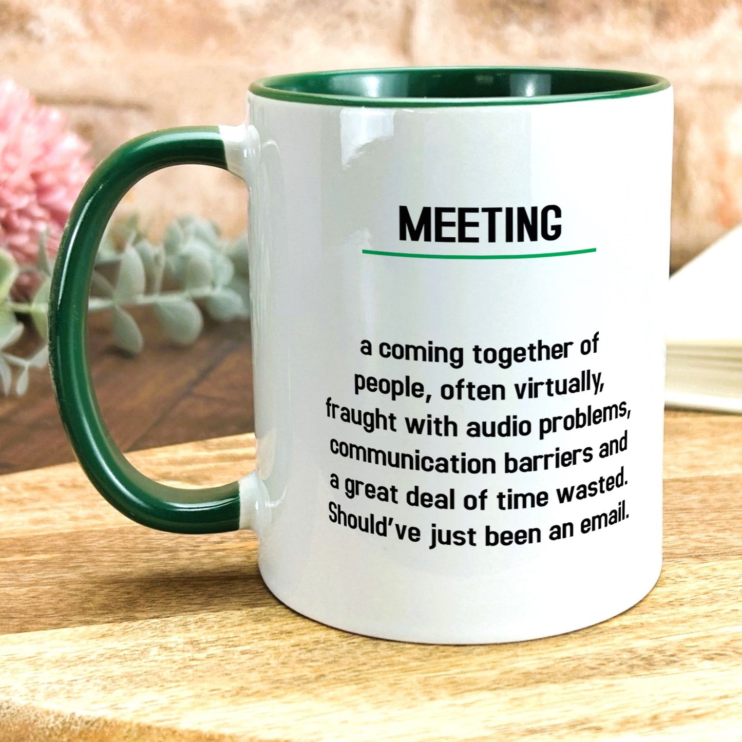 a green and white coffee mug sitting on top of a wooden table