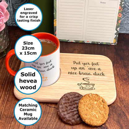 A wooden tray with a white mug and two cookies on it, along with a note pad and a pen holder.