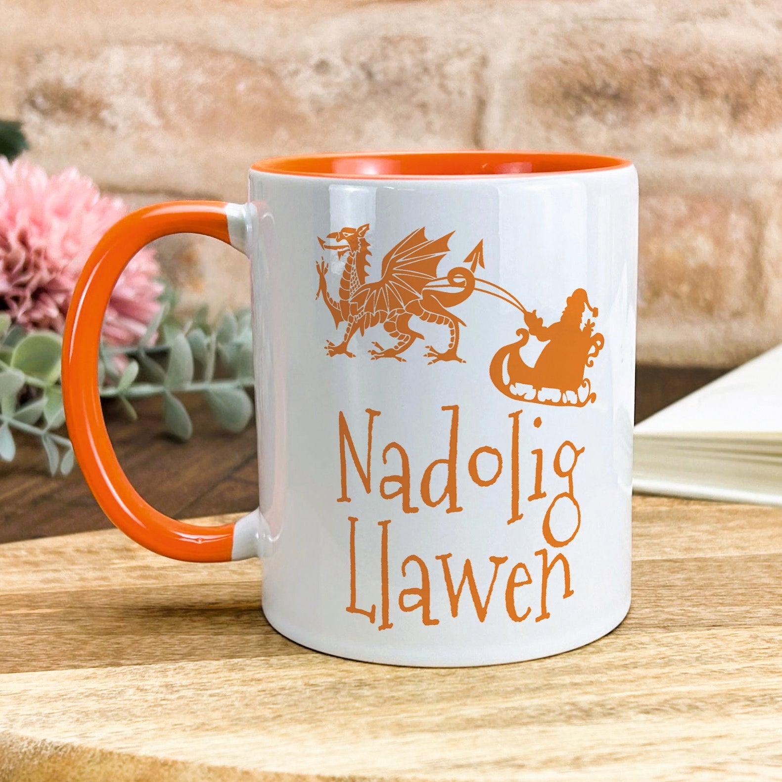 a white and orange coffee mug sitting on top of a wooden table