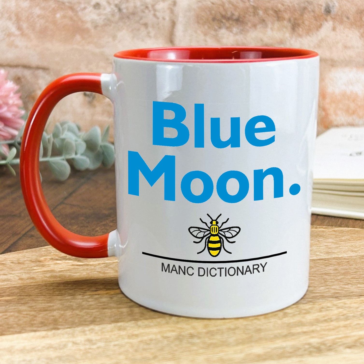 a red and white coffee mug with a blue moon on it