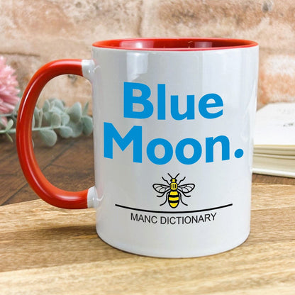 a red and white coffee mug with a blue moon on it