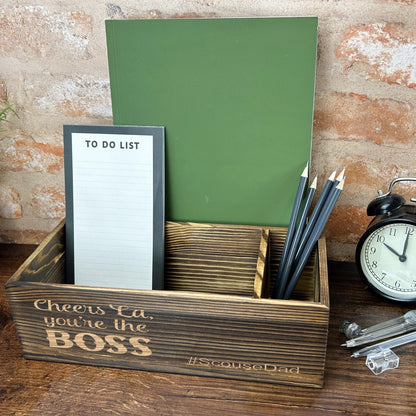 a desk with a clock, notepad and pen holder