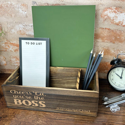 a desk with a clock, notepad and pen holder