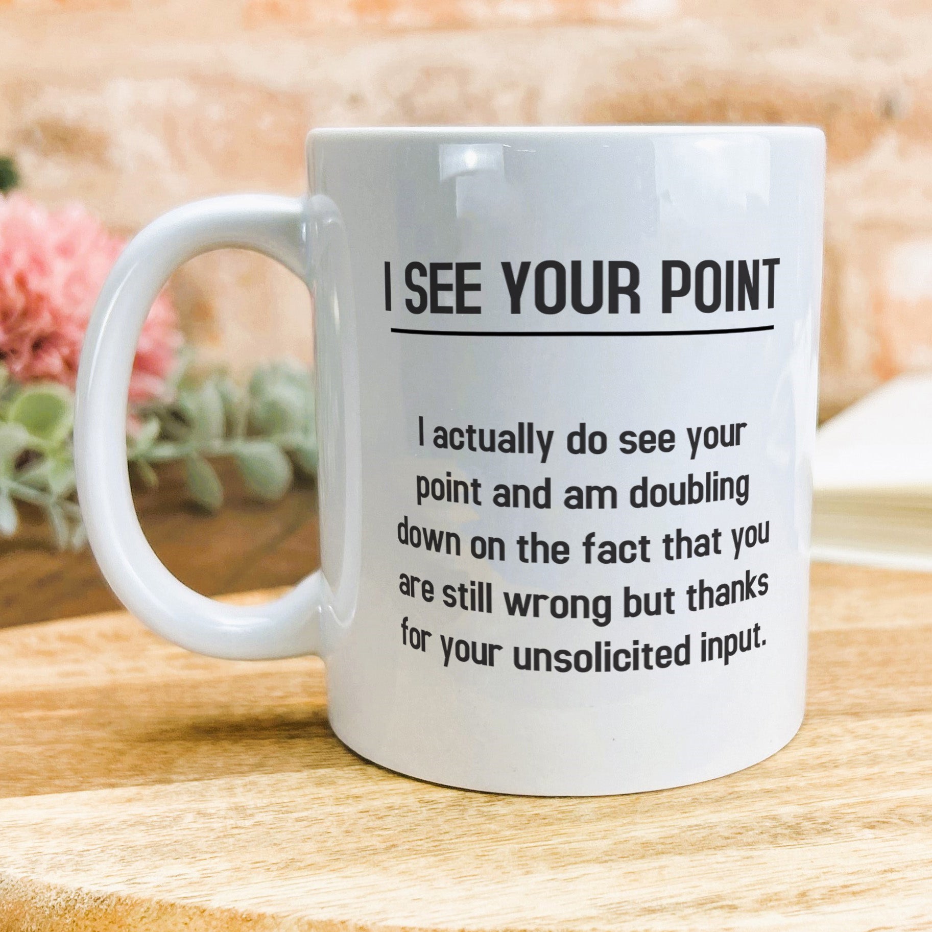 a white coffee mug sitting on top of a wooden table