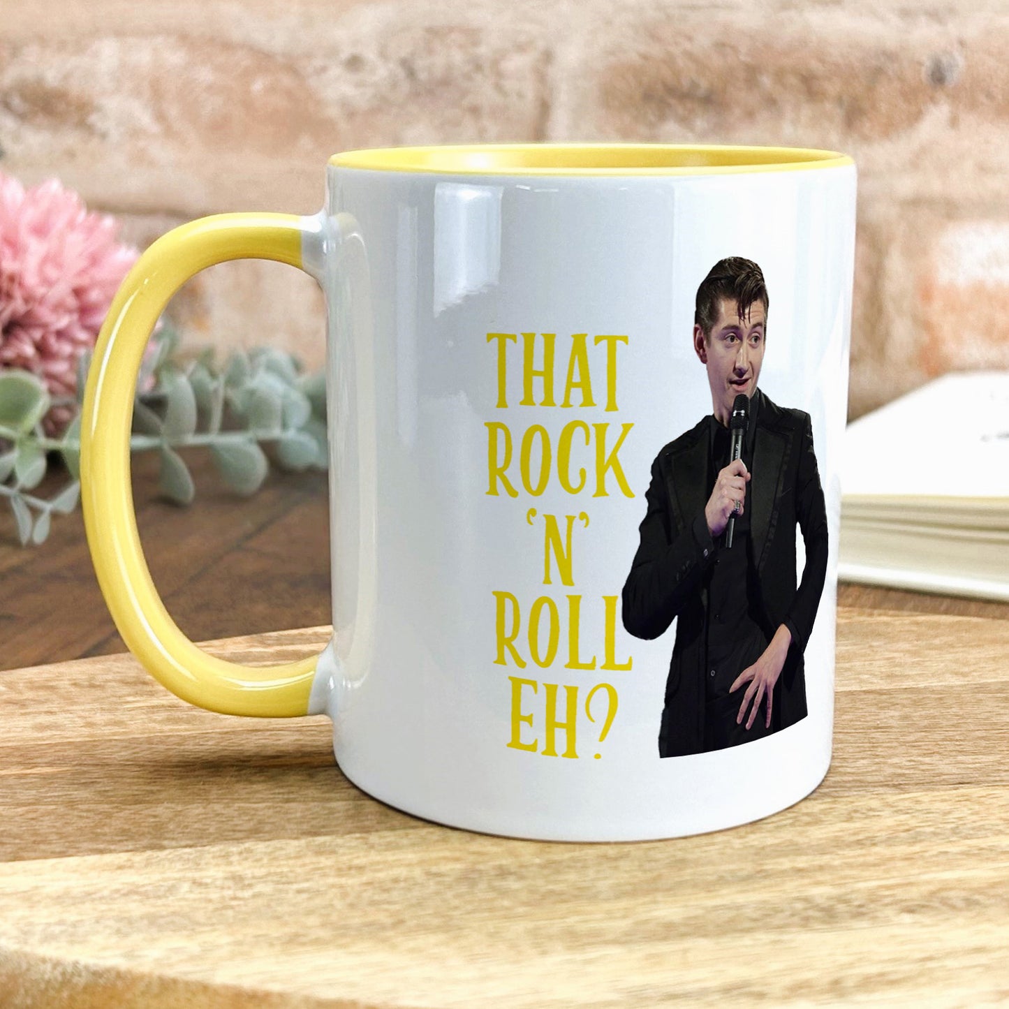 a yellow and white coffee mug with a picture of a man holding a microphone