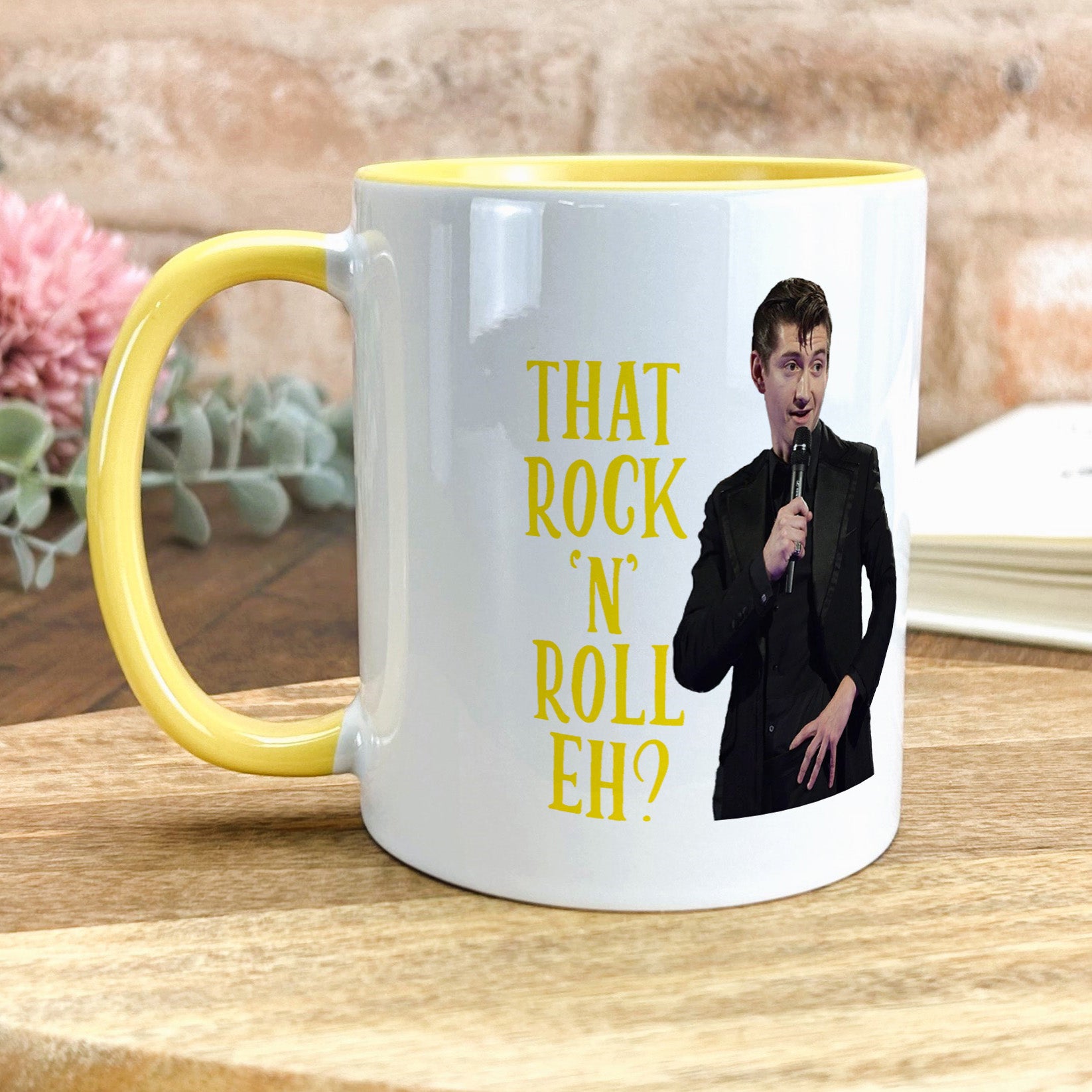 a yellow and white coffee mug with a picture of a man holding a microphone