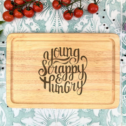 a cutting board with the words young, scrappy, hungry on it