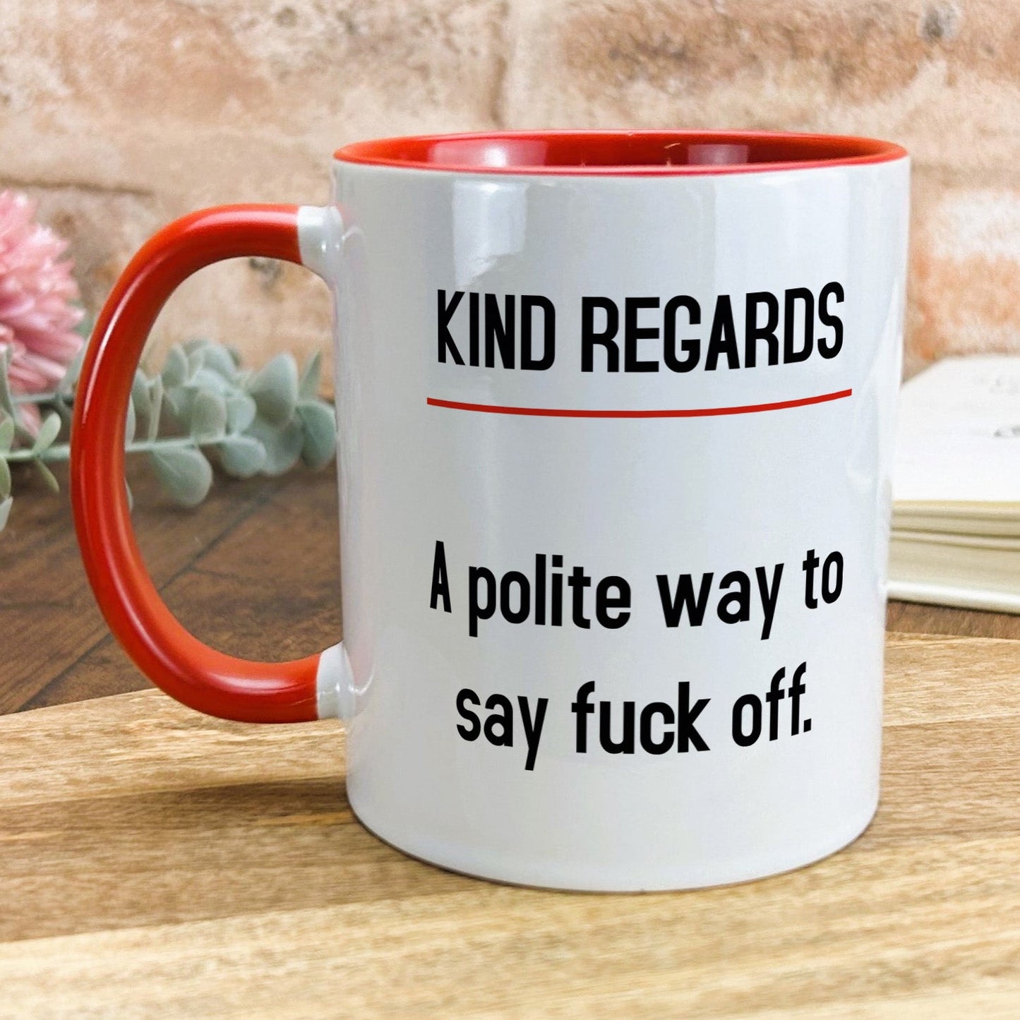 a red and white coffee mug sitting on top of a wooden table