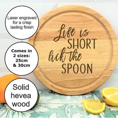 a wooden cutting board with the words life is short but the spoon