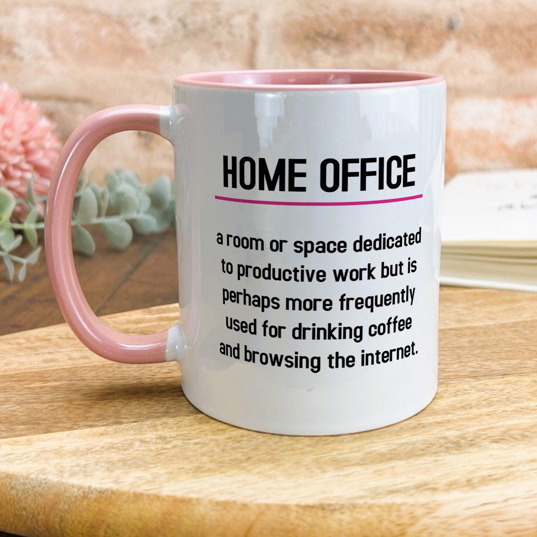 a pink and white coffee mug sitting on top of a wooden table