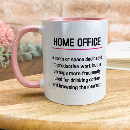 a pink and white coffee mug sitting on top of a wooden table