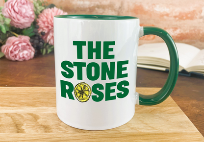 a green and white coffee mug with the stone roses on it