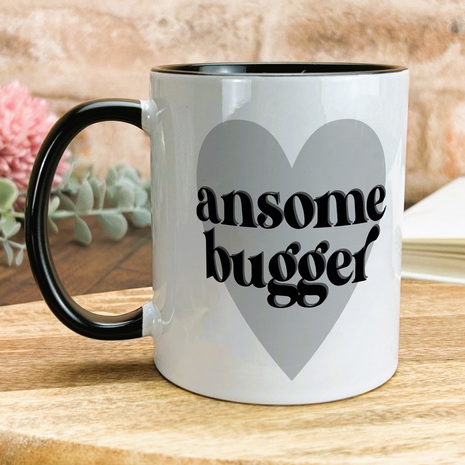 a black and white coffee mug with the words awesome bugger on it