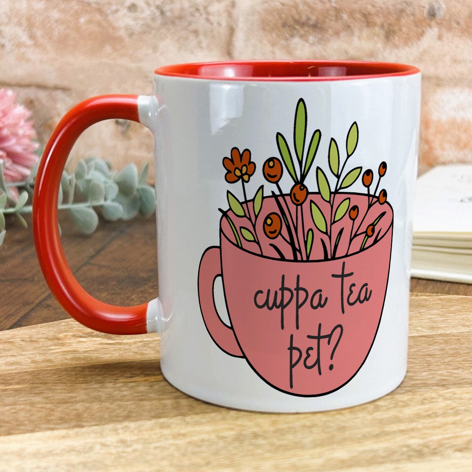 a red and white coffee mug with flowers in it