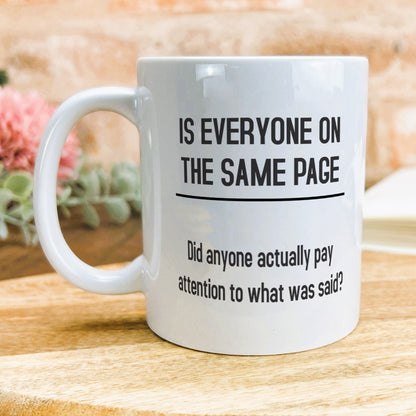 a white coffee mug sitting on top of a wooden table