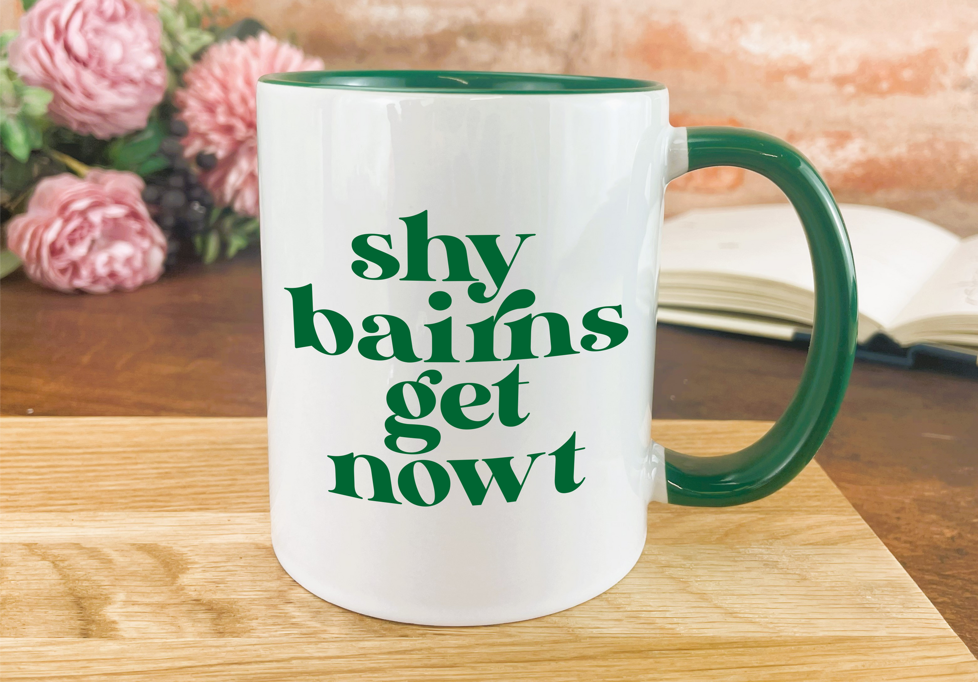 a green and white coffee mug sitting on top of a wooden table