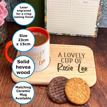 A wooden tray with a mug and two cookies on it, along with a note pad and a vase of flowers.