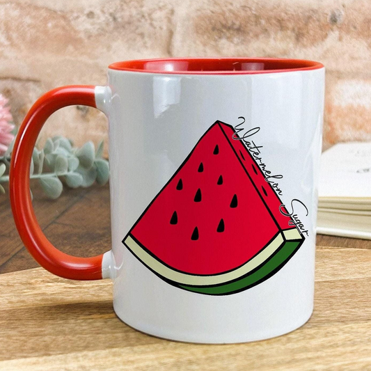 A white mug with a red rim, featuring a graphic of a slice of watermelon.