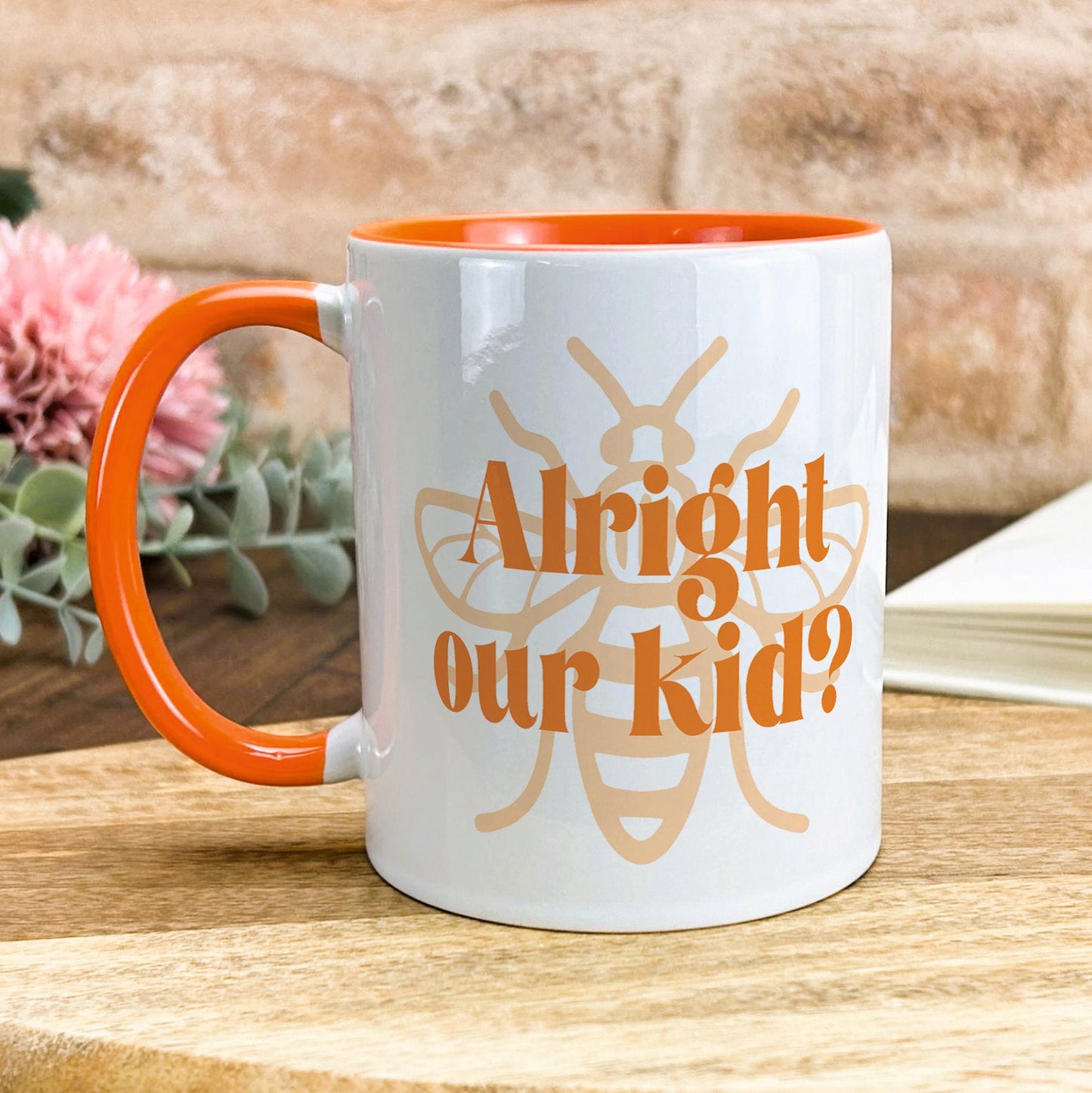 a white and orange coffee mug sitting on top of a wooden table