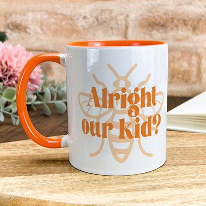 a white and orange coffee mug sitting on top of a wooden table