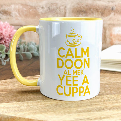 a yellow and white coffee mug sitting on top of a wooden table