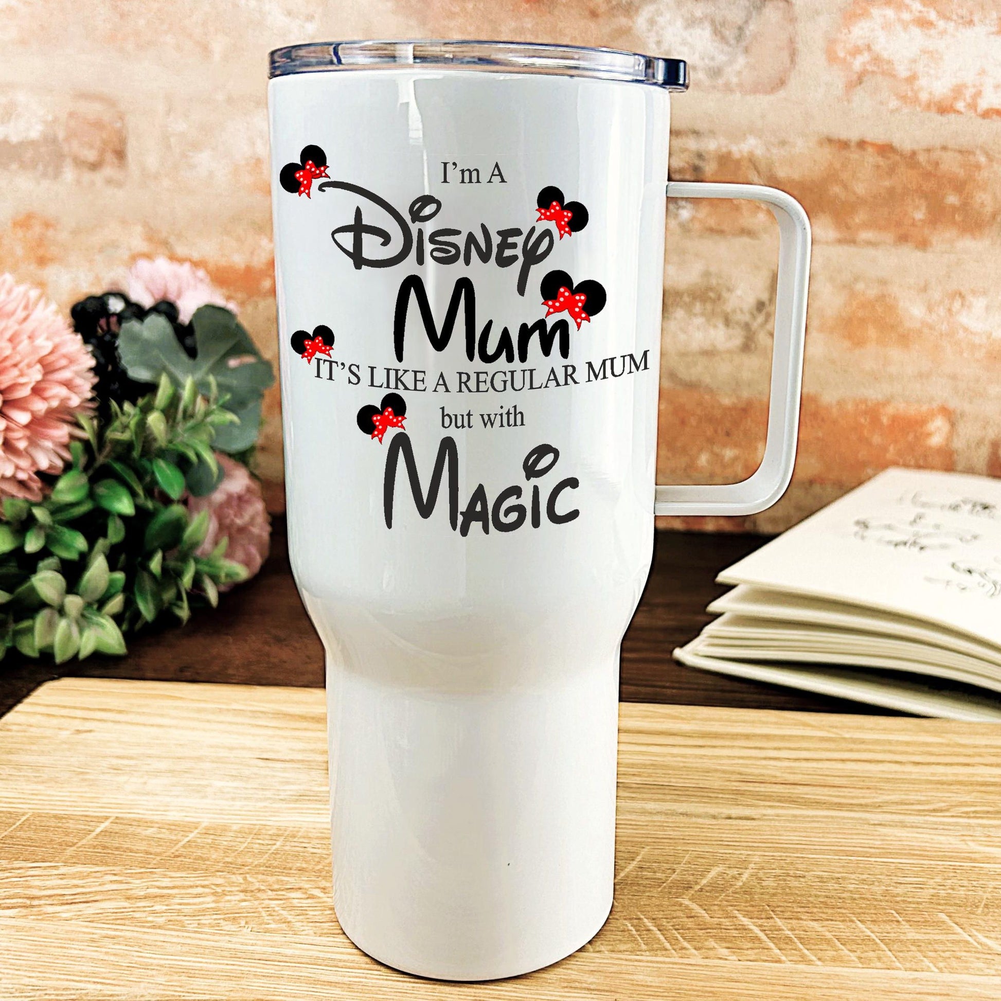 a white travel mug sitting on top of a wooden table