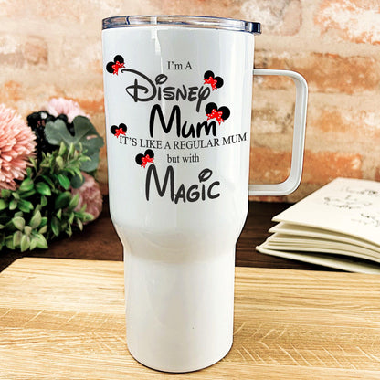 a white travel mug sitting on top of a wooden table