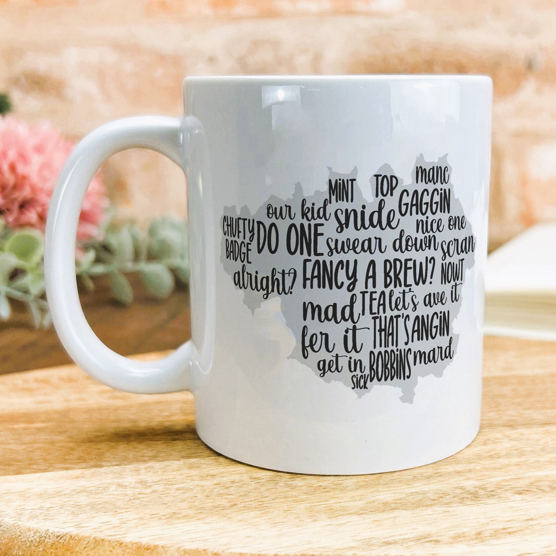 a white coffee mug sitting on top of a wooden table