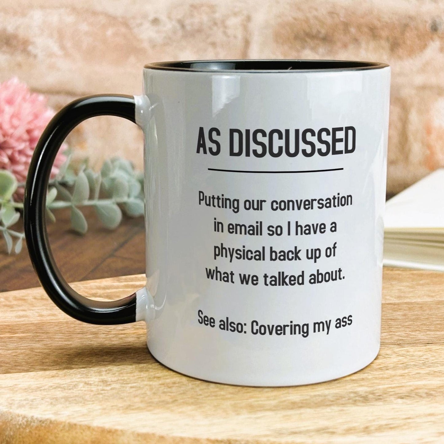 a black and white coffee mug on a wooden table