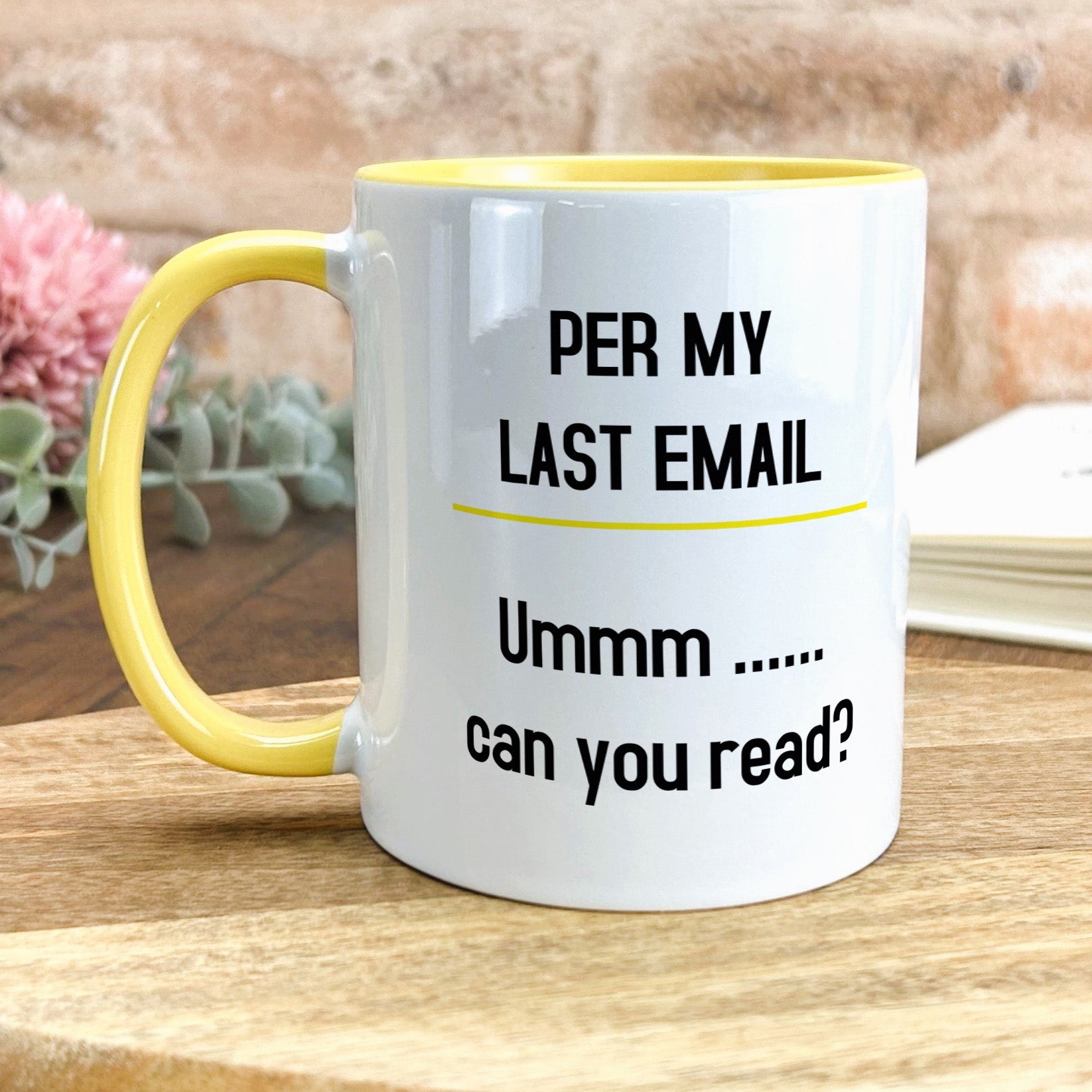 a yellow and white coffee mug sitting on top of a wooden table