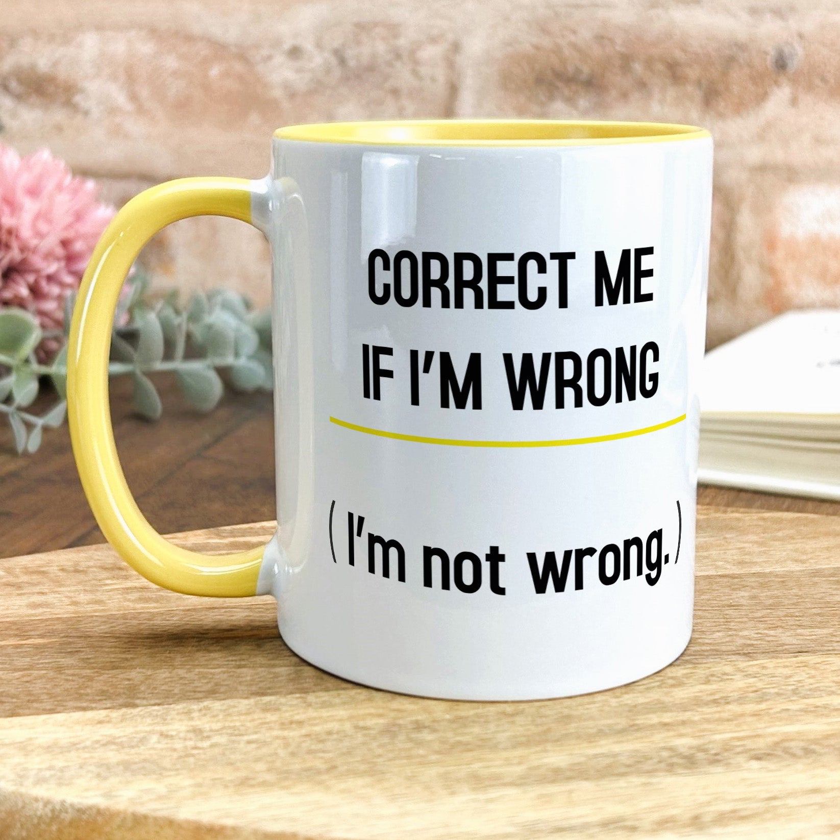 a yellow and white coffee mug sitting on top of a wooden table