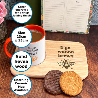 a wooden tray with a mug and two cookies on it, along with a note pad and a vase of flowers.