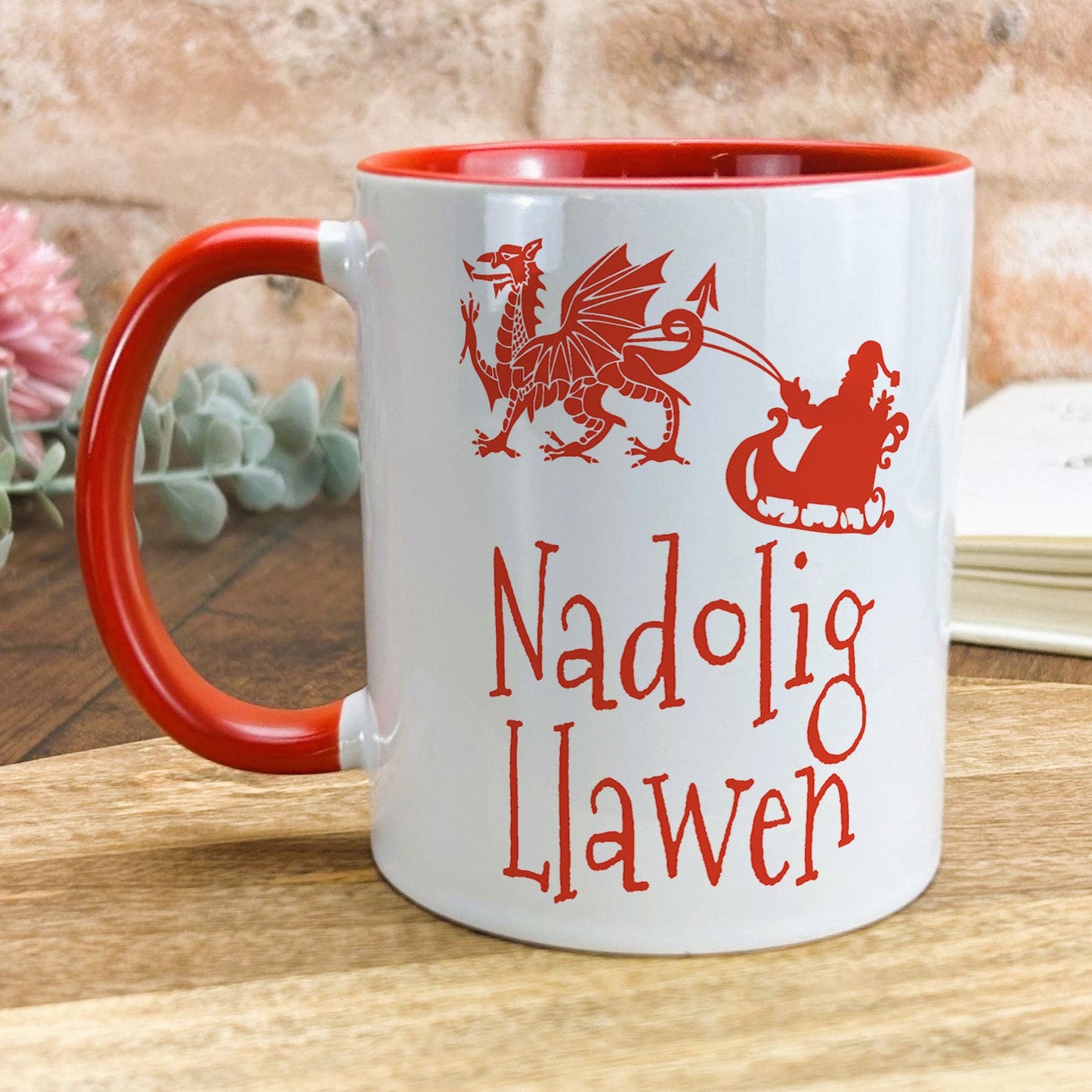 a red and white mug sitting on top of a wooden table