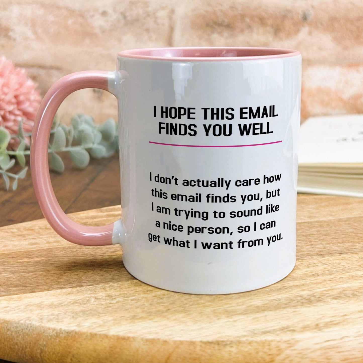a pink and white coffee mug sitting on top of a wooden table