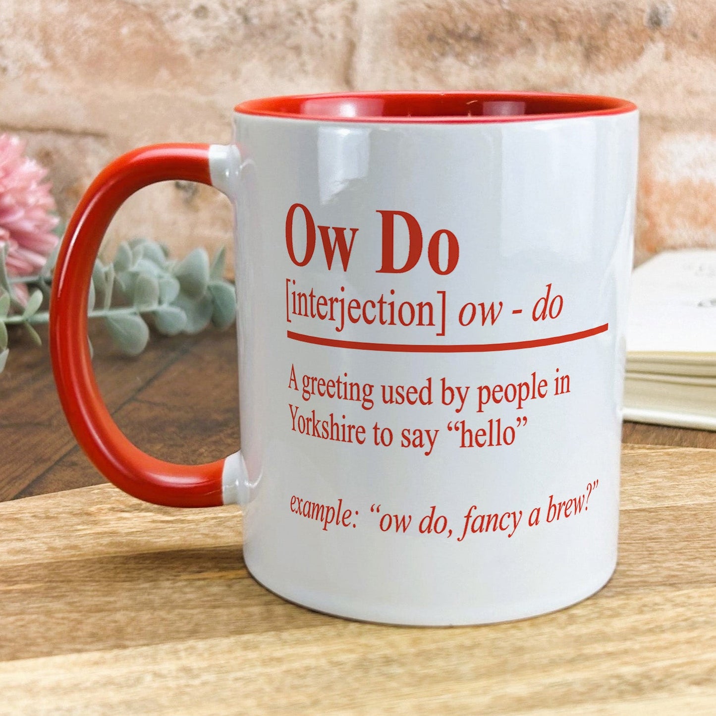 a red and white coffee mug sitting on top of a wooden table