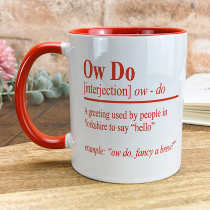 a red and white coffee mug sitting on top of a wooden table