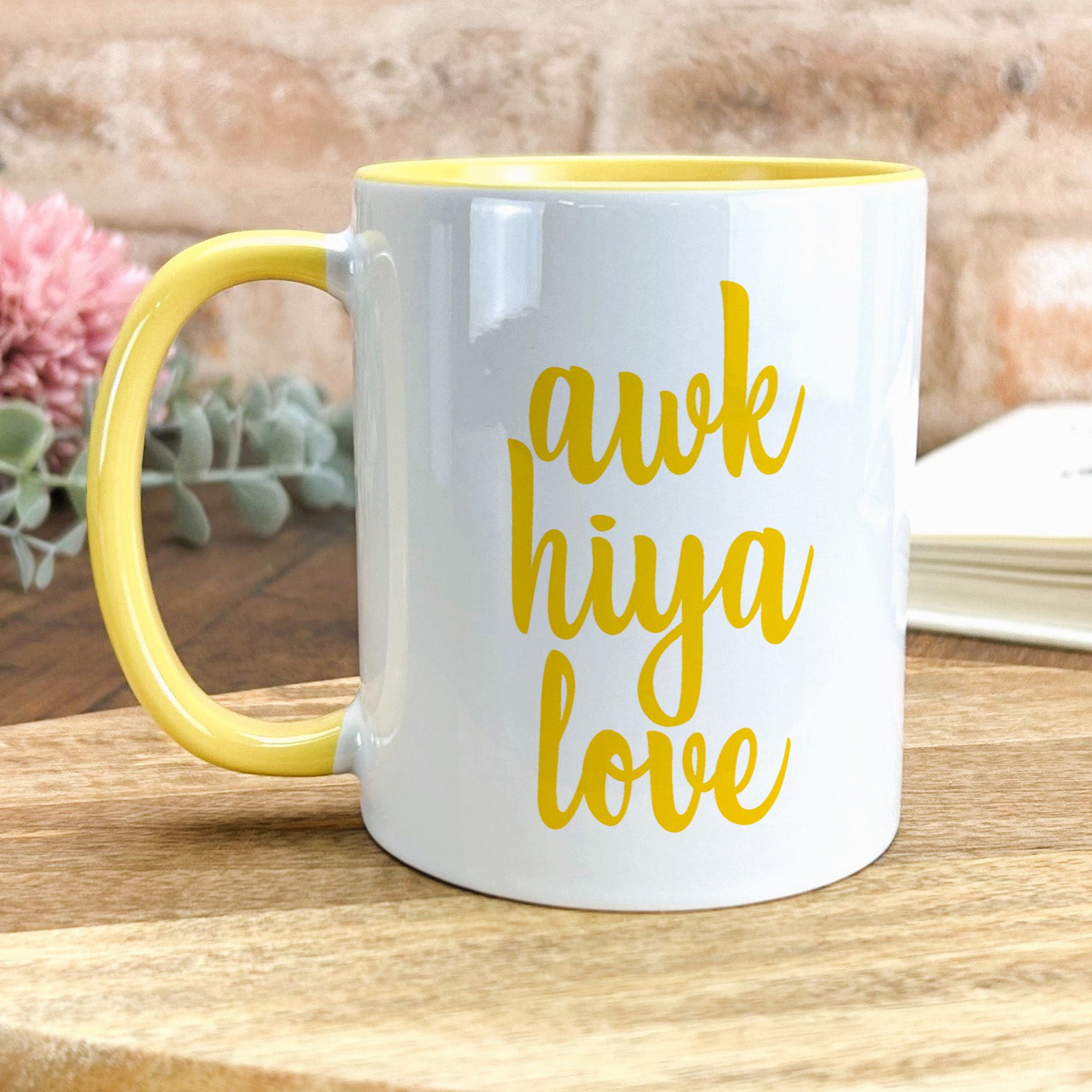 a yellow and white coffee mug sitting on top of a wooden table